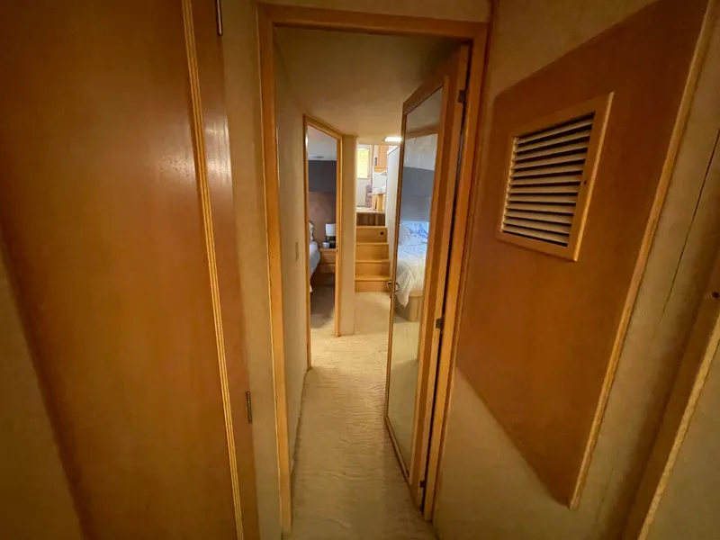 Slide: The Image of Hallway inside 1988 Hatteras 55 Convertible yacht, featuring wooden doors and carpeted flooring. - 42