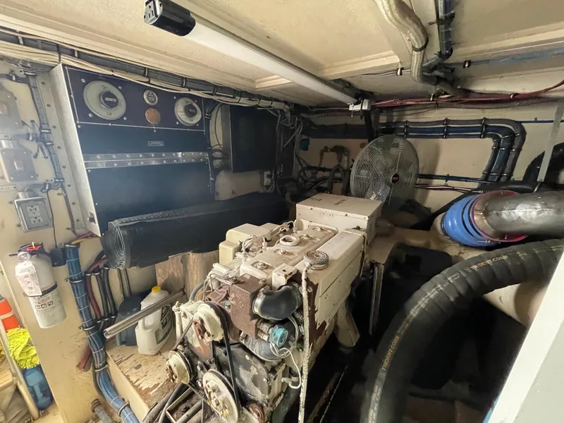 Slide: The Image of Engine room of 1988 Hatteras 55 Convertible yacht, featuring machinery and control panels. - 49