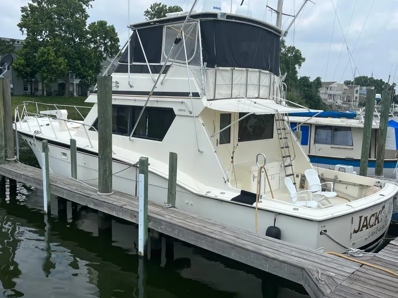 Slide: The Image of 1988 Hatteras 55 Convertible yacht docked at marina, side view. - 5