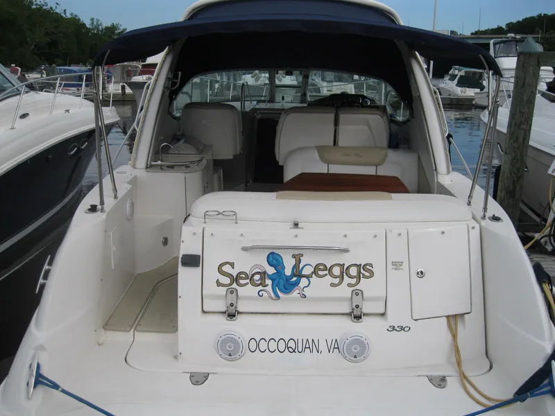 Slide: The Image of 2008 Sea Ray 330 Sundancer boat docked, rear view with "Sea Leggs" name. - 3