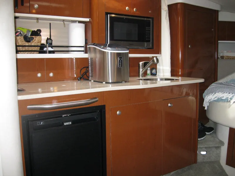 Slide: The Image of Interior of 2008 Sea Ray 330 Sundancer with kitchenette, featuring microwave and mini fridge. - 33
