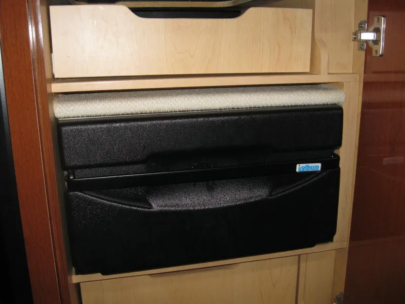 Slide: The Image of Cabinet storage inside 2008 Sea Ray 330 Sundancer boat, featuring black and beige compartments. - 38