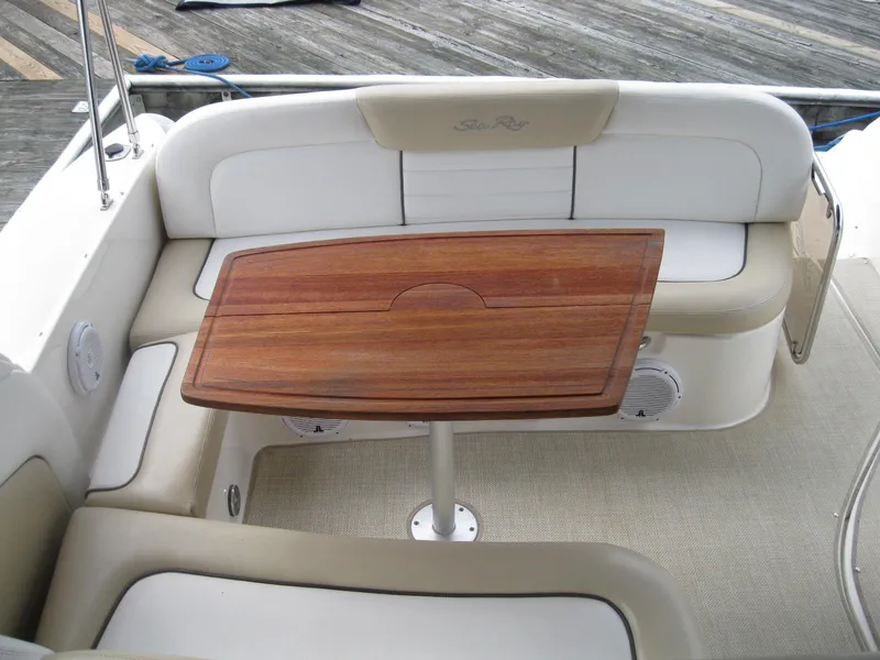 Slide: The Image of 2008 Sea Ray 330 Sundancer cockpit with wooden table and cushioned seating. - 7