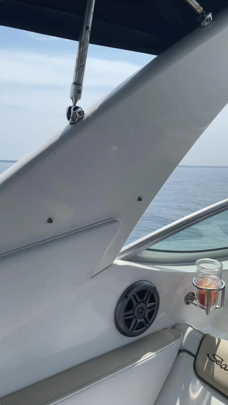 Slide: The Image of 2015 Sea Ray 280 Sundancer boat interior with speaker and drink holder, ocean view. - 20