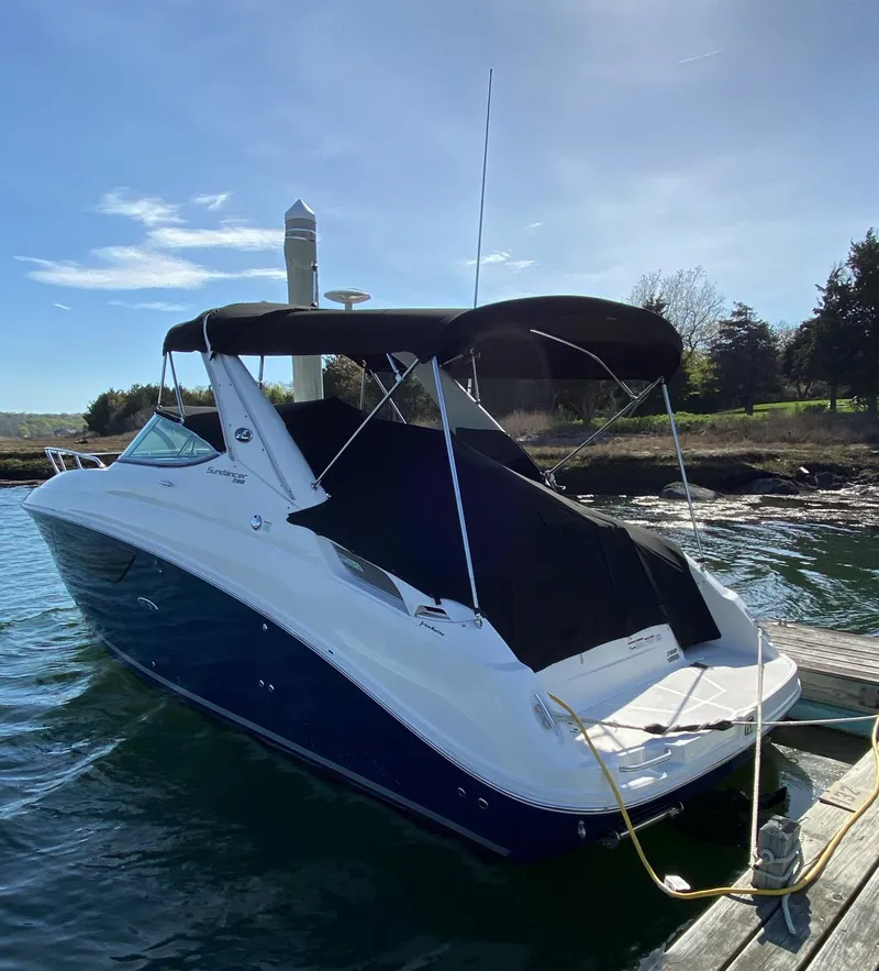 Slide: The Image of 2015 Sea Ray 280 Sundancer boat docked on calm water under clear sky. - 30
