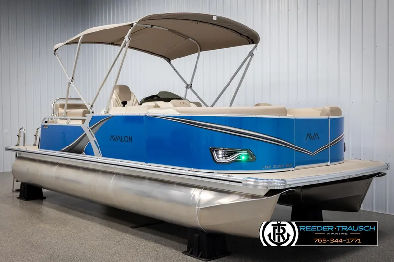 Slide: The Image of 2025 Avalon LSZ QLS pontoon boat with blue exterior and canopy in showroom. - 3