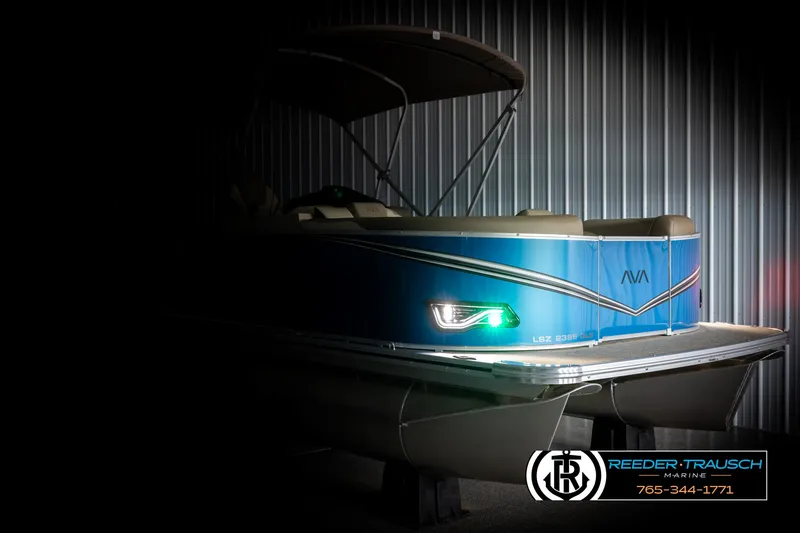Slide: The Image of 2025 Avalon LSZ QLS pontoon boat with sleek design and illuminated details in a dimly lit setting. - 4