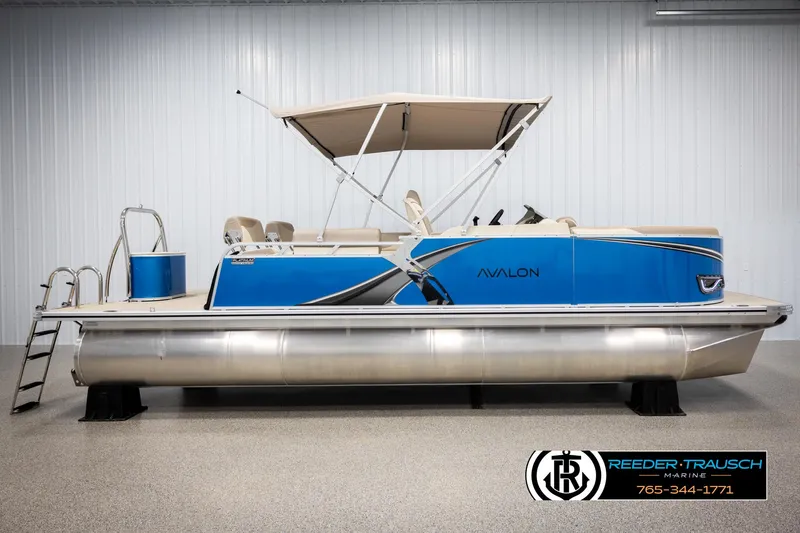 Slide: The Image of 2025 Avalon LSZ QLS pontoon boat with blue exterior and canopy in showroom. - 5