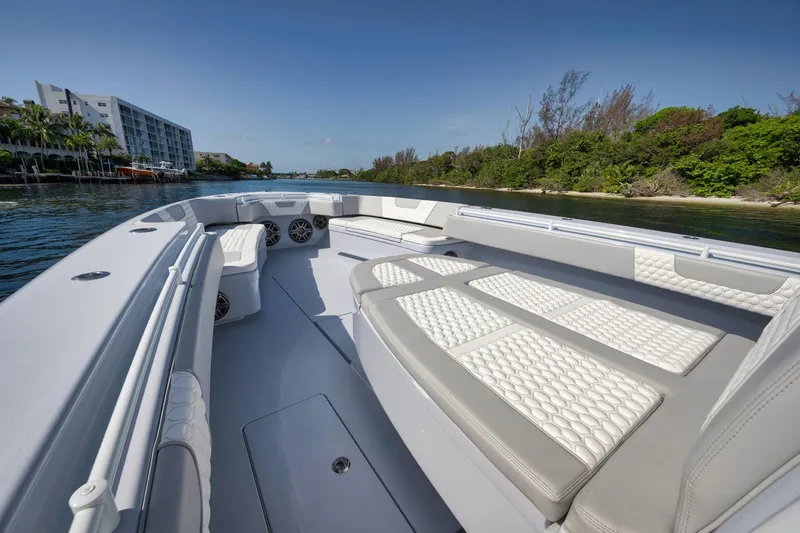 Slide: The Image of 2025 Contender 44 ST boat with spacious seating, cruising on a scenic waterway. - 11