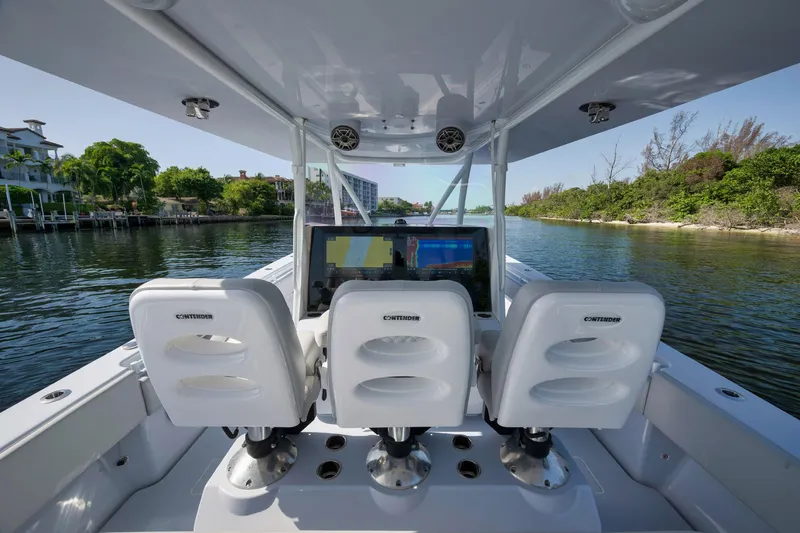 Slide: The Image of 2025 Contender 44 ST boat interior with three white seats and navigation screens. - 24