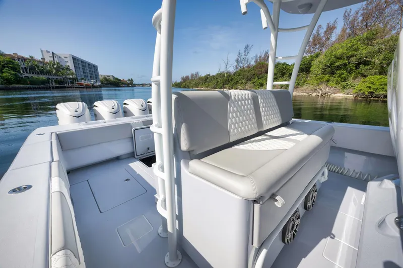 Slide: The Image of 2025 Contender 44 ST boat interior with seating, docked near lush greenery and calm waters. - 25