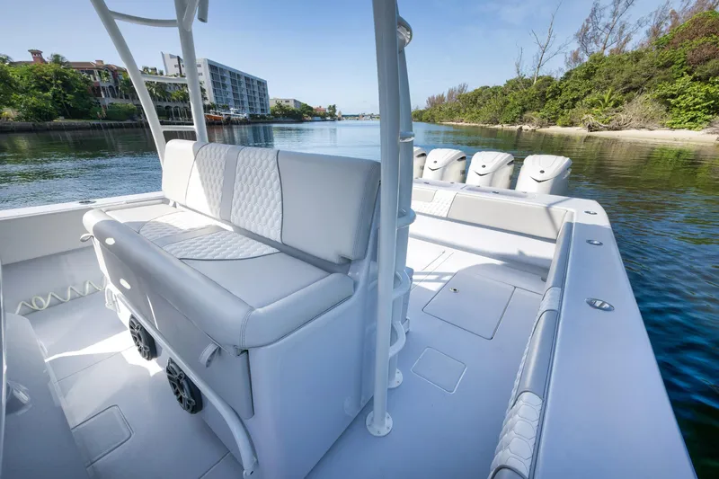 Slide: The Image of 2025 Contender 44 ST boat with sleek white seating and powerful engines on a calm waterway. - 27