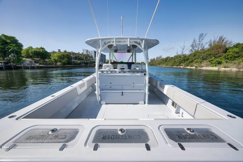 Slide: The Image of 2025 Contender 44 ST boat on calm water, showcasing spacious deck and sleek design. - 32