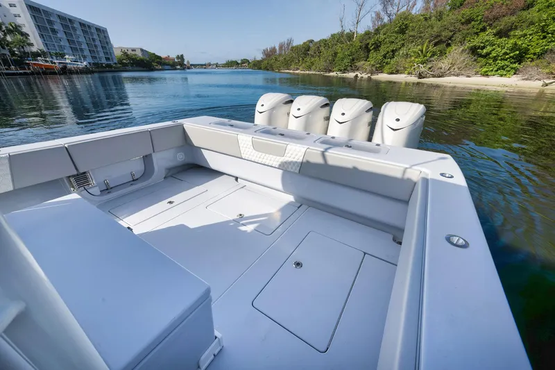 Slide: The Image of 2025 Contender 44 ST boat with multiple engines, docked in a scenic waterway. - 35