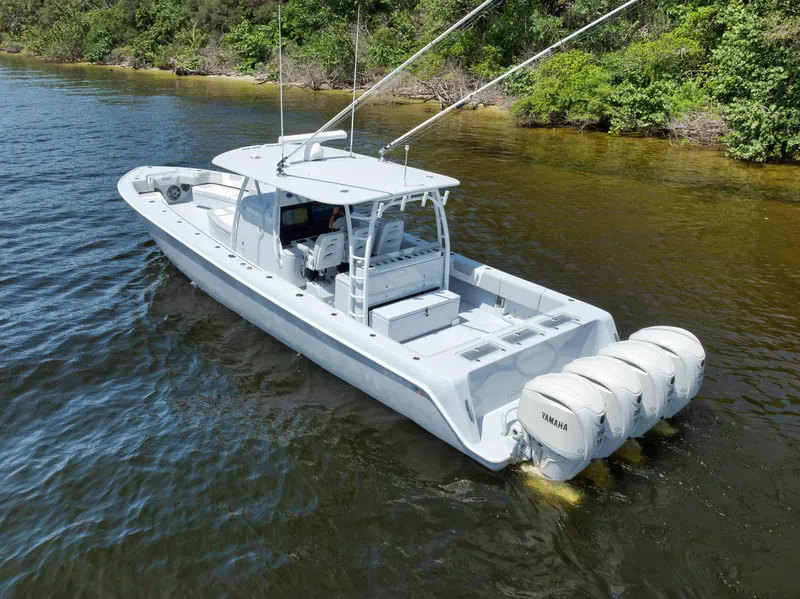 Slide: The Image of 2025 Contender 44 ST boat with triple Yamaha engines on a calm river. - 49