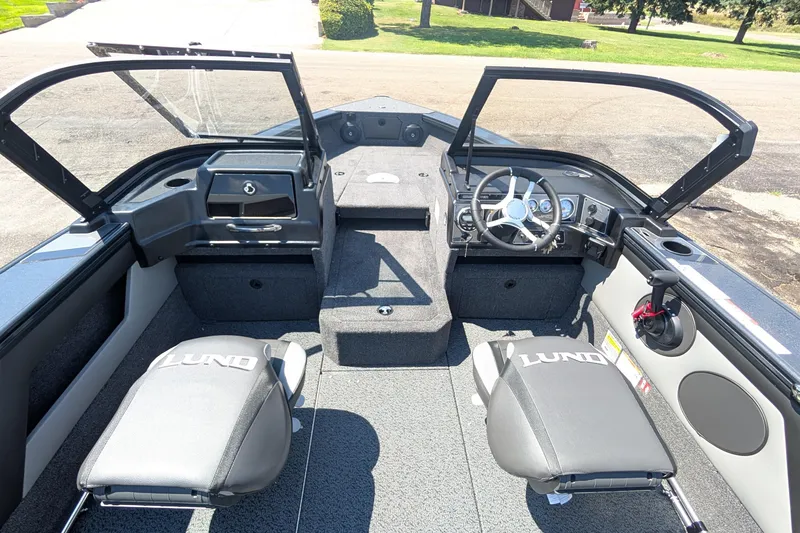 Slide: The Image of 2026 Lund 1875 Crossover XS boat interior with open windshield and seating. - 14