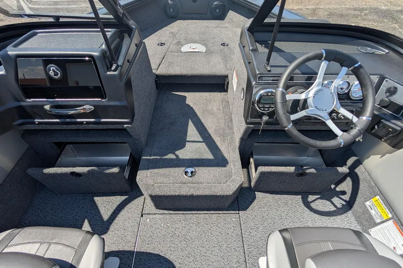 Slide: The Image of 2026 Lund 1875 Crossover XS boat interior with steering wheel and storage compartments. - 15