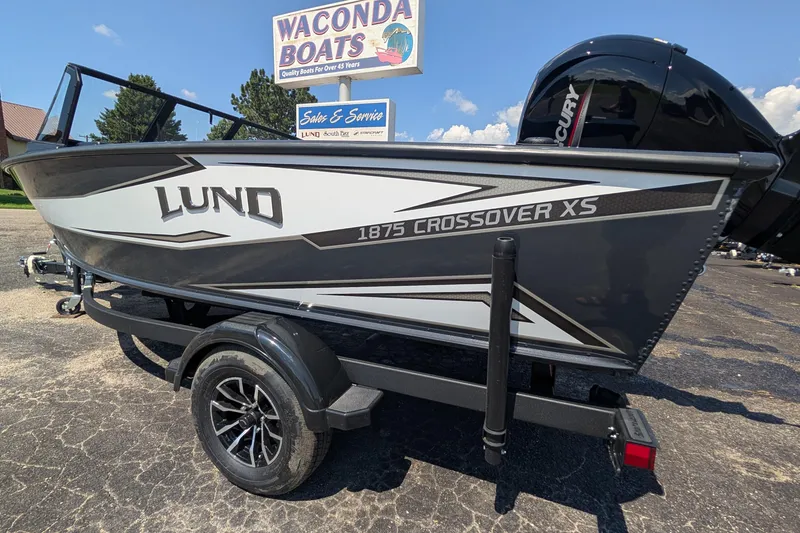 Slide: The Image of 2026 Lund 1875 Crossover XS boat on trailer at Waconda Boats dealership. - 3