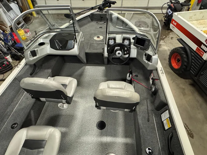 Slide: The Image of 2018 Tracker Pro Guide V-16 WT boat interior with seating and control panel. - 13