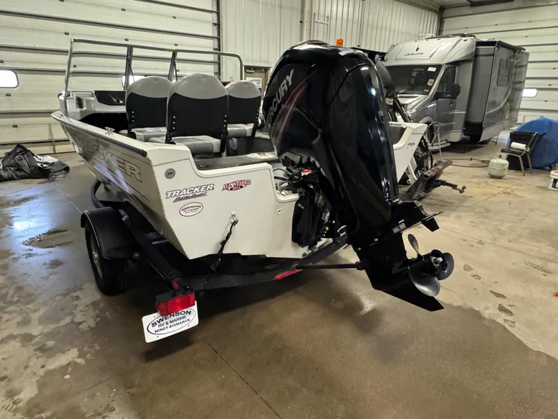 Slide: The Image of 2018 Tracker Pro Guide V-16 WT boat with Mercury outboard motor in a garage. - 4