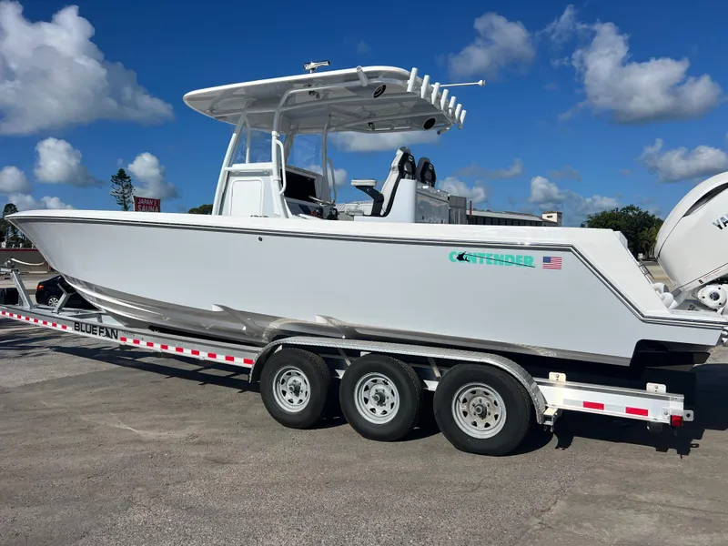 Slide: The Image of 2025 Contender 32 ST boat on a trailer under a clear blue sky. - 3