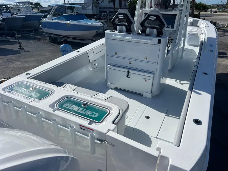Slide: The Image of 2025 Contender 32 ST boat with dual seats and storage, docked outdoors. - 6
