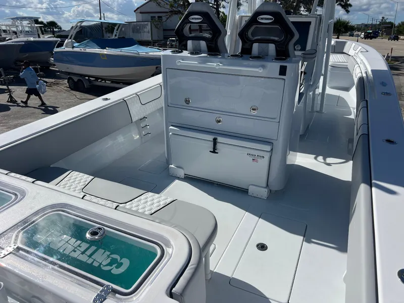 Slide: The Image of 2025 Contender 32 ST boat interior with seating and storage, docked under sunny skies. - 7