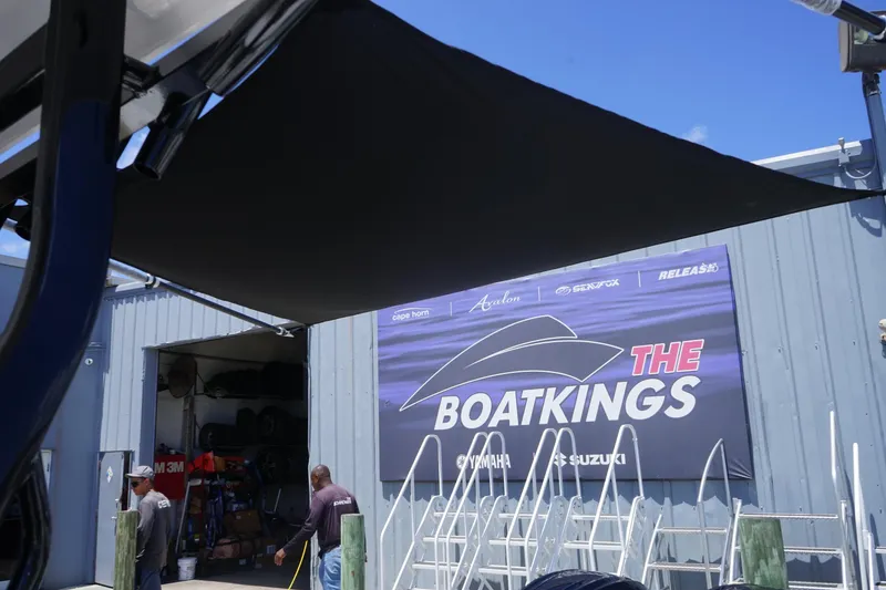 Slide: The Image of 2025 Sea Fox 328 Commander boat with sunshade, parked outdoors under clear blue sky. - 47