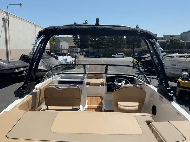 Slide: The Image of 2025 Bayliner VR5 Bowrider I/O with tan interior, parked outdoors under clear sky. - 11