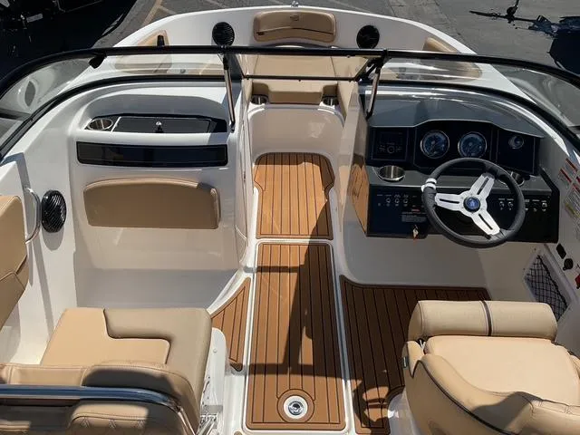 Slide: The Image of 2025 Bayliner VR5 Bowrider I/O interior with tan seating and wood-style flooring. - 13