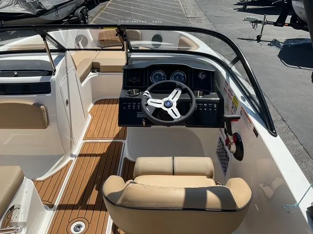 Slide: The Image of 2025 Bayliner VR5 Bowrider I/O interior with tan seating and modern dashboard. - 14