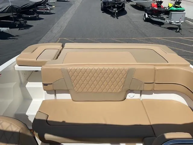 Slide: The Image of 2025 Bayliner VR5 Bowrider I/O with tan seating, parked on a marina lot. - 17