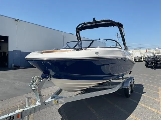 Slide: The Image of 2025 Bayliner VR5 Bowrider I/O on trailer, parked outdoors near industrial building. - 5