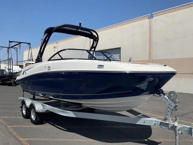 Slide: The Image of 2025 Bayliner VR5 Bowrider I/O on trailer, parked outdoors, sleek design, blue and white exterior. - 7