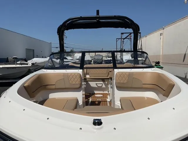 Slide: The Image of 2025 Bayliner VR5 Bowrider I/O with spacious seating and sleek design in a marina setting. - 9