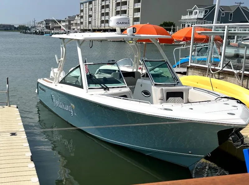 Slide: The Image of 2021 Sailfish 276 DC boat docked in a marina, featuring a sleek design and modern amenities. - 0