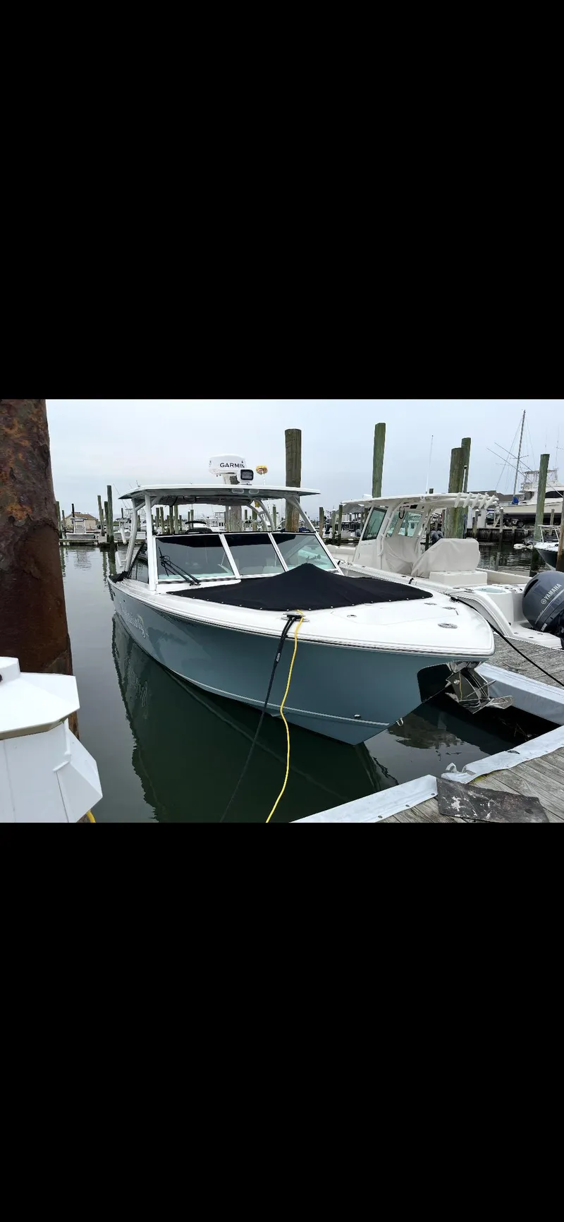 Slide: The Image of 2021 Sailfish 276 DC boat docked at marina, front view. - 1