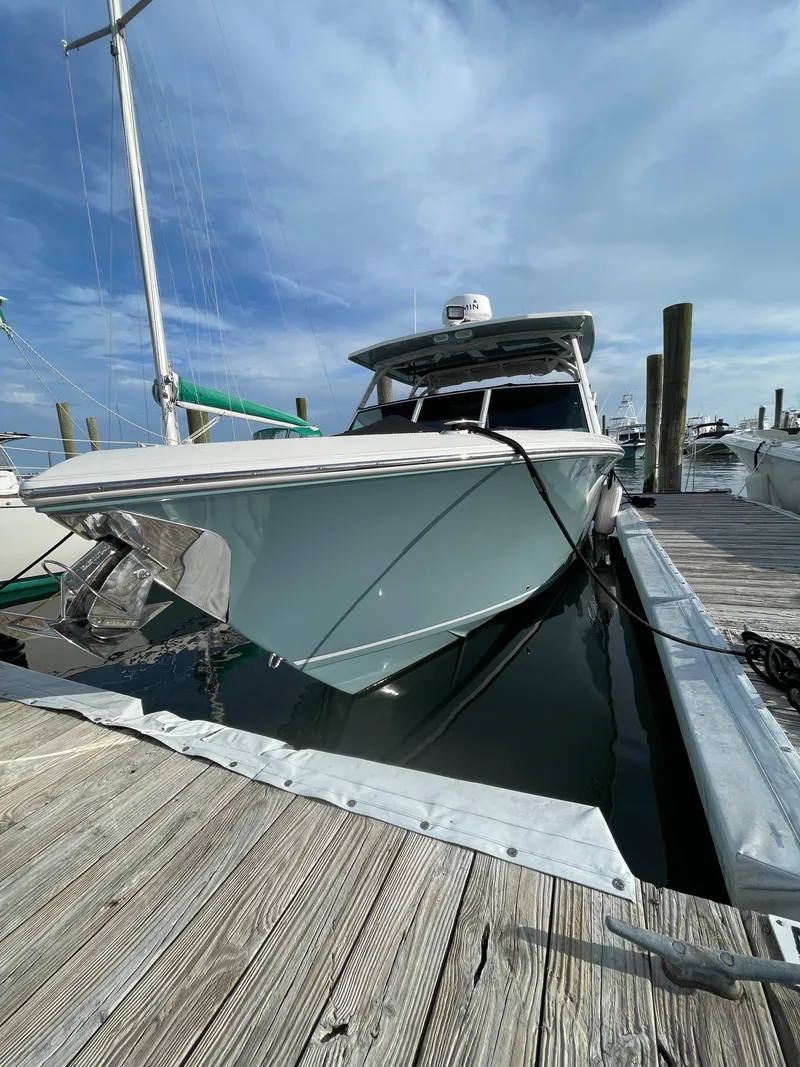 Slide: The Image of 2021 Sailfish 276 DC boat docked at marina under clear sky. - 10