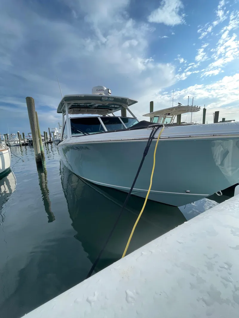 Slide: The Image of 2021 Sailfish 276 DC boat docked at marina under cloudy sky. - 11