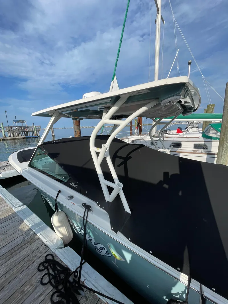 Slide: The Image of 2021 Sailfish 276 DC boat docked, featuring sleek design and sturdy canopy under a clear sky. - 13