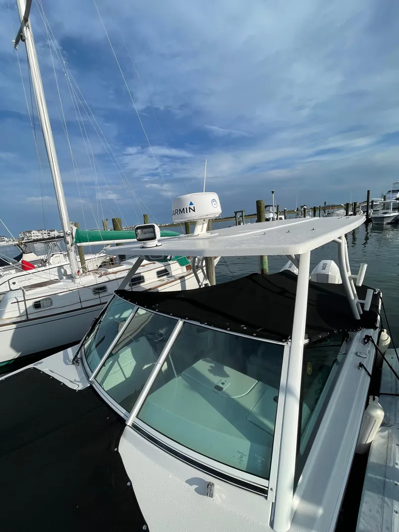 Slide: The Image of 2021 Sailfish 276 DC boat docked at marina under clear blue sky. - 14
