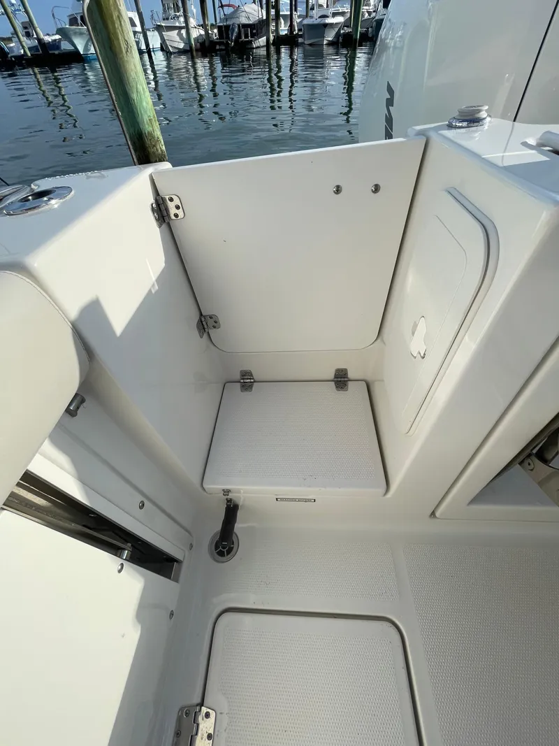 Slide: The Image of 2021 Sailfish 276 DC boat interior with storage compartment, docked by the water. - 23