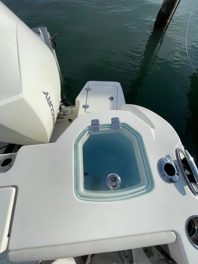 Slide: The Image of 2021 Sailfish 276 DC boat with livewell and Mercury engine, docked on calm water. - 26