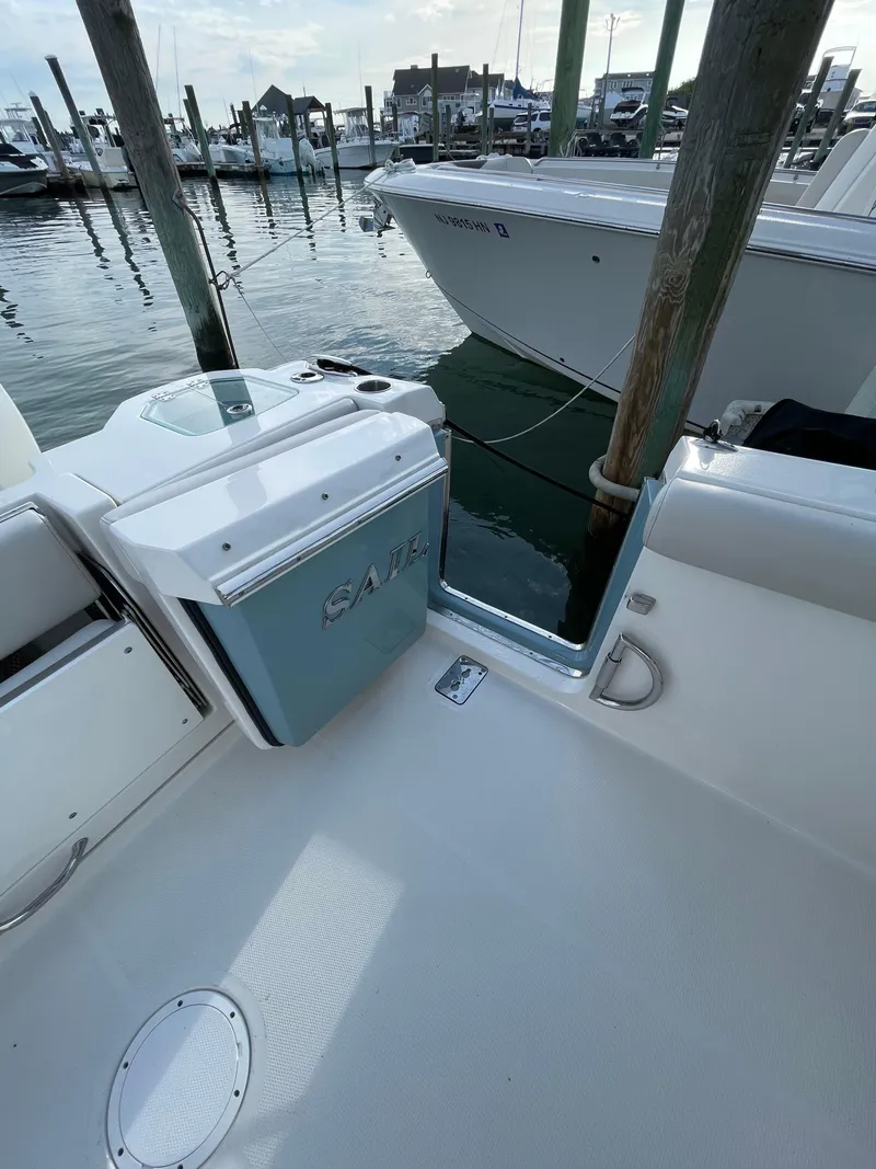 Slide: The Image of 2021 Sailfish 276 DC boat docked at marina, showcasing sleek design and spacious deck. - 29