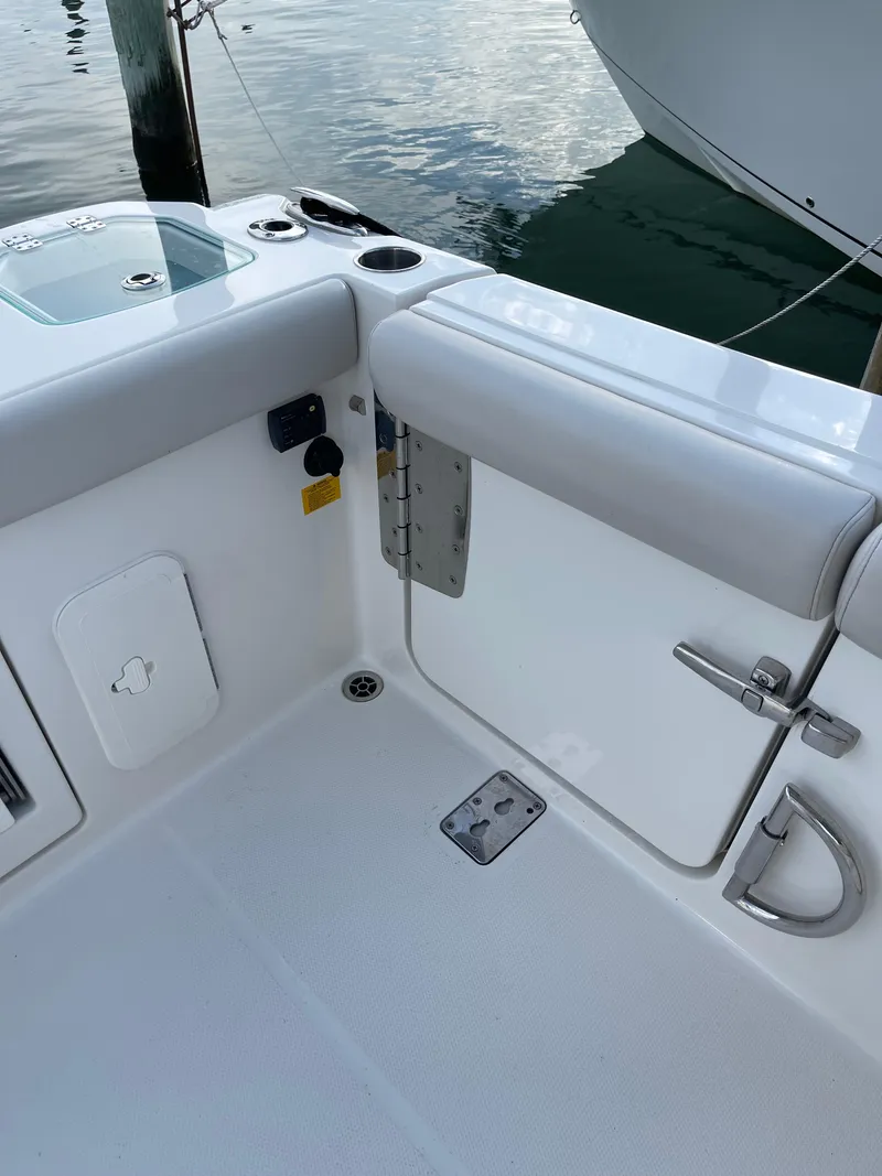 Slide: The Image of 2021 Sailfish 276 DC boat interior with white seating and storage compartments. - 30