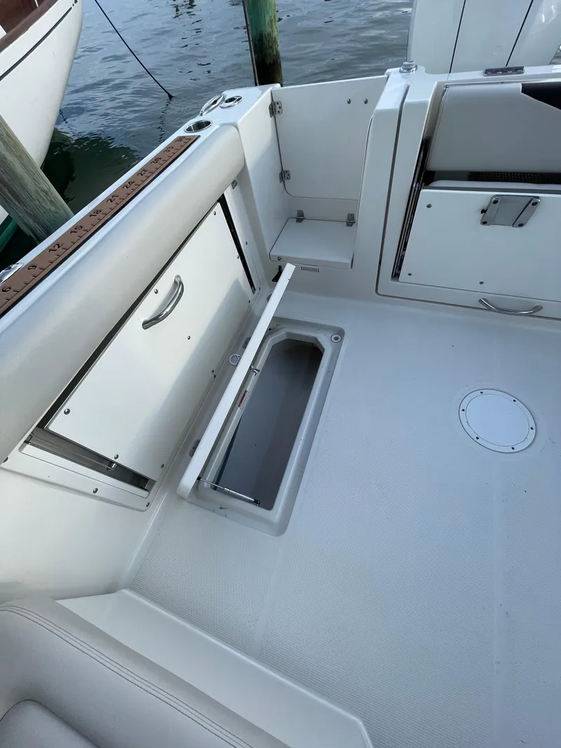 Slide: The Image of 2021 Sailfish 276 DC boat interior with storage compartments and seating area. - 36