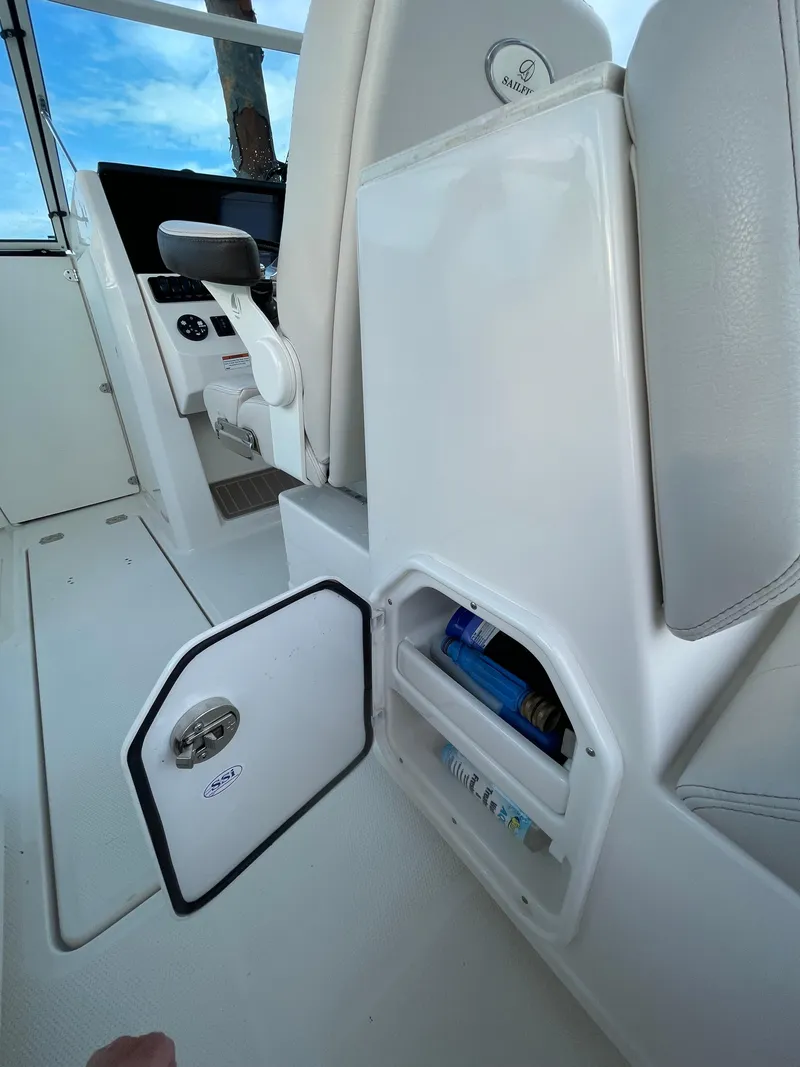 Slide: The Image of 2021 Sailfish 276 DC boat interior with open storage compartment and modern dashboard. - 37
