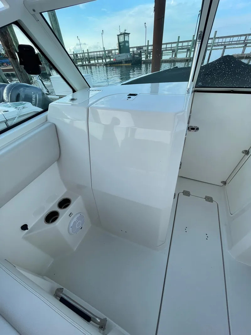 Slide: The Image of 2021 Sailfish 276 DC boat interior with cup holders, dock view, and modern design. - 45