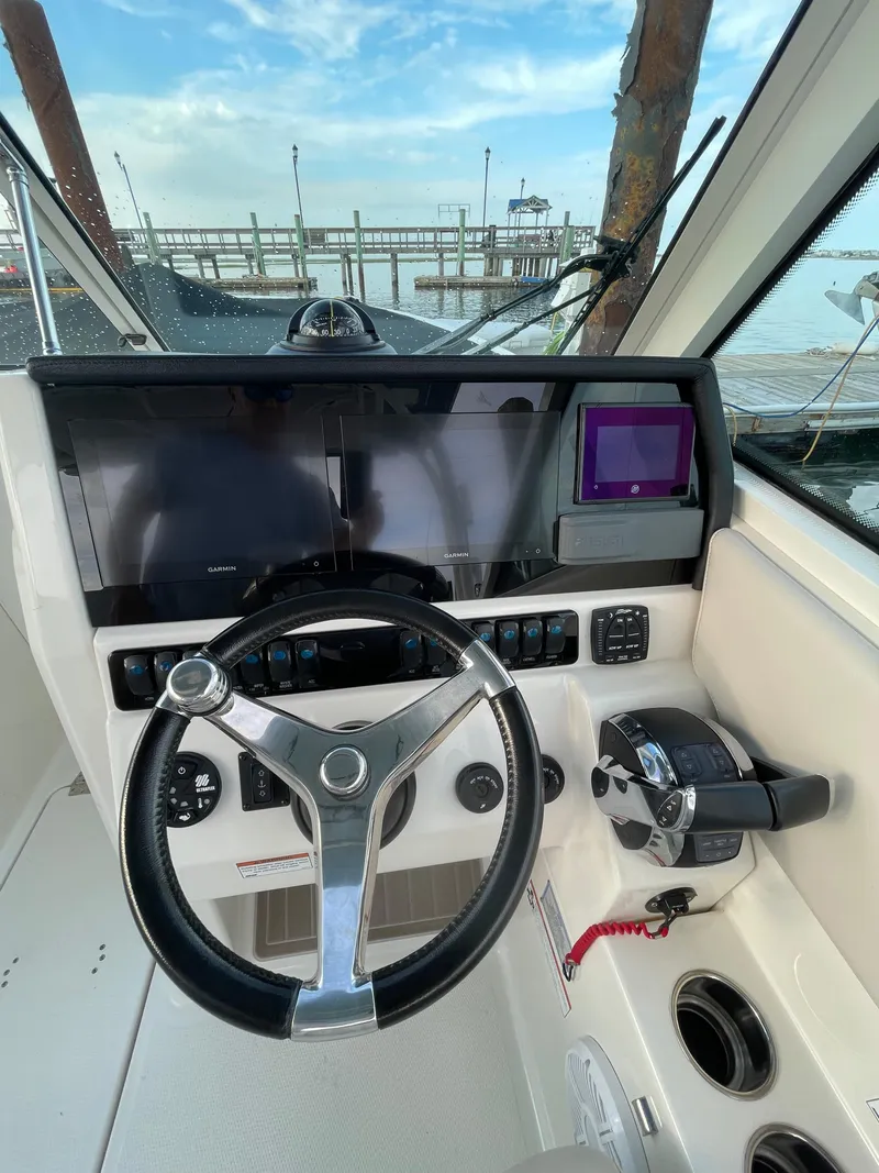 Slide: The Image of 2021 Sailfish 276 DC boat cockpit with steering wheel and control panel. - 47