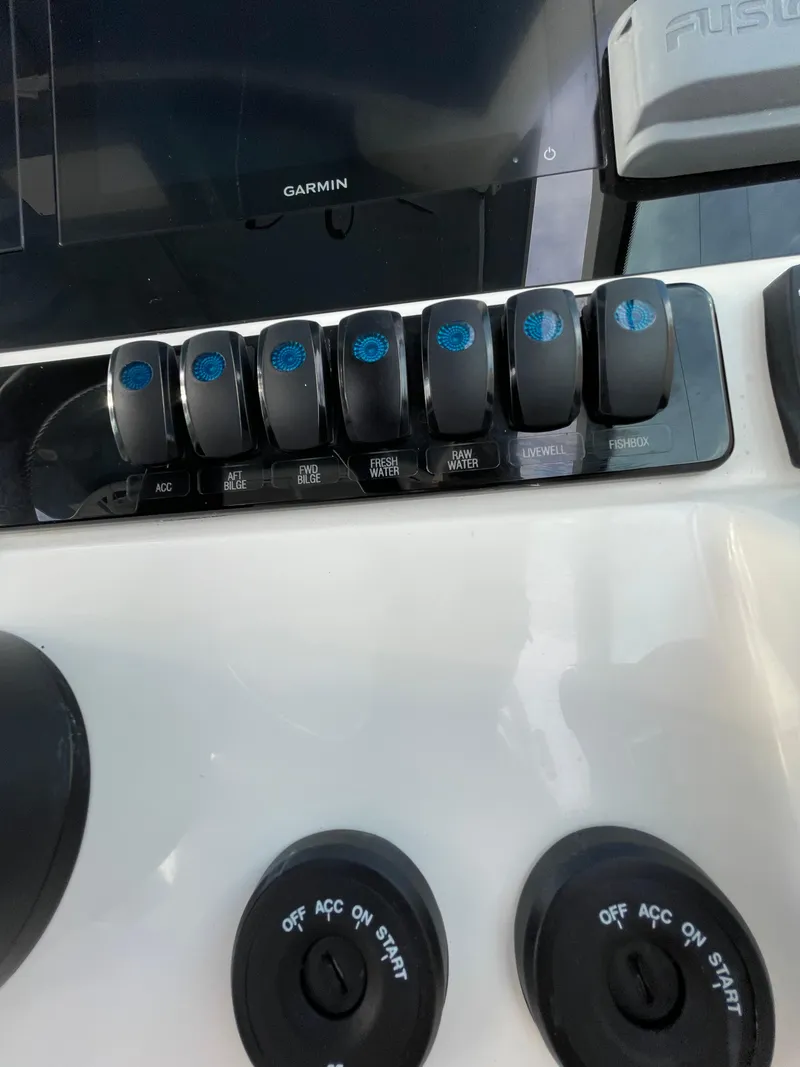 Slide: The Image of Control panel of 2021 Sailfish 276 DC boat with switches and dials. - 49